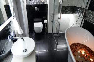een badkamer met een wastafel, een bad en een toilet bij DIAMOND LADY Romantyczny i Luksusowy Apartament in Szczecin