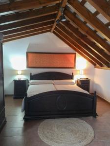 a bedroom with a large black bed with wooden ceilings at Posada Alegria in Medina Sidonia