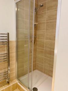 a shower with a glass door in a bathroom at Swandown Hotel in Swindon +12 photos