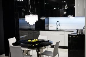 a black and white kitchen with a table and chairs at DIAMOND LADY Romantyczny i Luksusowy Apartament in Szczecin