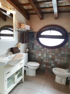a bathroom with a toilet and a sink and a window at Posada Alegria in Medina Sidonia