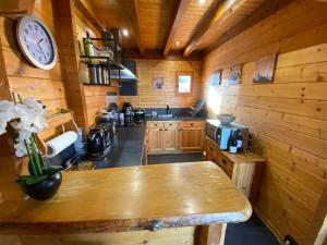 a kitchen with a table and a clock on the wall at Haut de Chalet L'entasse n°9 in Valberg +26 photos