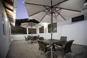 a dining room with tables and chairs with umbrellas at West House Lusitania in San Andrés