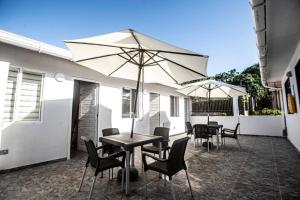 a table and chairs with an umbrella on a patio at West House Lusitania in San Andrés