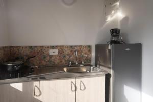 a kitchen with a sink and a refrigerator at West House Lusitania in San Andrés +21 photos