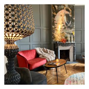 a living room with a red chair and a table at VILLA DU CEDRE Honfleur in Honfleur