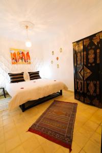 ein Schlafzimmer mit einem Bett und einem Teppich auf dem Boden in der Unterkunft La Voûte Étoilée in Marrakesch