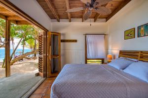 una camera da letto con un letto e un ventilatore a soffitto di Camp Bay Lodge a Roatán