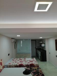 een slaapkamer met een bed en een plafond met een raam bij Sol Victoria Marina Lofts in Salvador