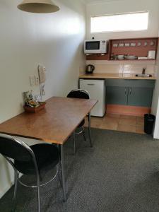 a kitchen with a table and chairs in a room at Bks Egmont Motor Lodge in New Plymouth
