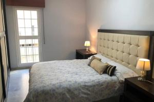 a bedroom with a large bed with two night stands and two lamps at CENTRO CONFORT TRANQUILO Y LUMINOSO WIFI TV in Ceuta