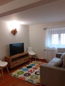 a living room with a couch and a flat screen tv at La Calleja del Canchal in Arenas de San Pedro