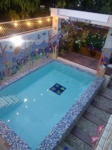 a swimming pool at night with a painting on the wall at Casa de Mony in Santa Marta