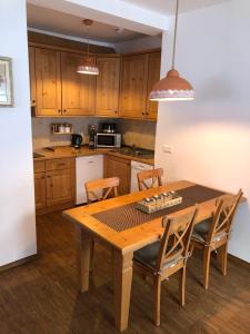 a kitchen with a wooden table with two chairs and a table and a kitchen with at Apartma Lenka Kranjska Gora in Kranjska Gora