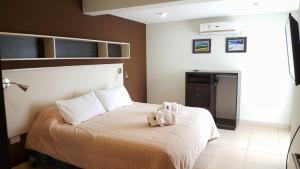 um quarto com uma cama com um bicho de peluche em Carnaval p/6 - 2 dorm - Amplio y a 5' del centro em Salta