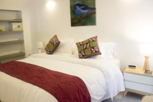 1 dormitorio con cama blanca y manta roja en Cotinga Hotel Spa, en Pereira