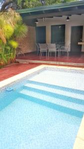 una piscina con sillas y una mesa en una casa en Pachamama - Depto p/4 nuevo y a 5' del centro en Salta