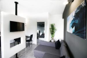 uma sala de estar com um sofá e uma televisão em Surf House la Palma em Fuencaliente de la Palma
