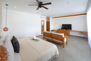 
a living room with a bed and a tv at Hotel Blanco Tulum in Tulum
