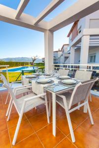 a white dining table and chairs on a patio with a view at Benestar In Jalon Valley in Alcalalí