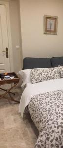 1 dormitorio con 2 camas y mesa en Apartamento Córdoba Mezquita, en Córdoba