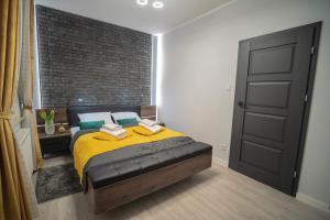 sypialnia z łóżkiem i ceglaną ścianą w obiekcie Apartament w Cieplicach 3 Delux w Jeleniej Górze