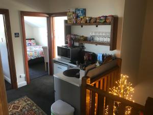 a small kitchen with a sink and a microwave at Sandy Feet Lodge in Christchurch