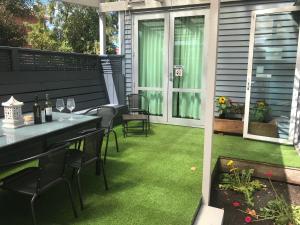 un patio con prato verde, tavolo e sedie di Sandy Feet Lodge a Christchurch