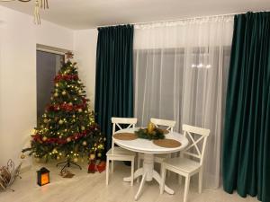 a dining room with a christmas tree and a table and chairs at Studio 16 Predeal in Predeal