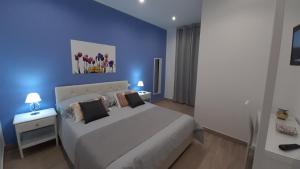 niebieska sypialnia z łóżkiem i 2 szafkami nocnymi w obiekcie A Casa di Josephine w mieście Palermo