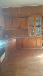 a kitchen with wooden cabinets and a tile floor at The Red Rose City in Wadi Musa
