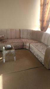 a large couch in a living room with a table at The Red Rose City in Wadi Musa