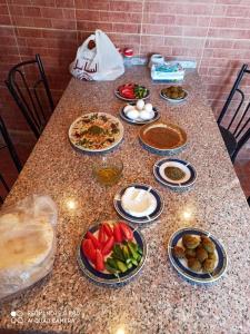 una mesa con platos de comida encima en The Red Rose City, en Wadi Musa