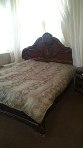 1 cama con cabecero de madera en un dormitorio en The Red Rose City, en Wadi Musa