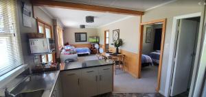 a kitchen with a sink and a living room at Roxburgh Clutha Gold TOP 10 Holiday Park in Roxburgh