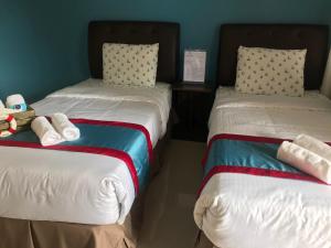 2 lits avec des animaux farcis dans une pièce dans l'établissement ANCHORAGE INN Moalboal, à Moalboal