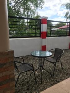 a patio with two chairs and a table and a window at ANCHORAGE INN Moalboal in Moalboal