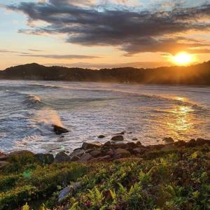 un tramonto sulla riva di uno specchio d'acqua di Recanto Vó Terezinha a Imbituba