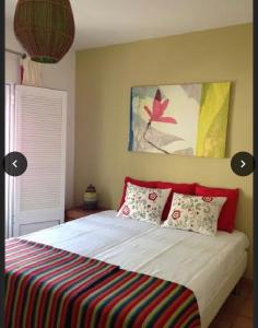 um quarto com uma cama com um cobertor listrado colorido em Casa de férias na Praia Verde Casa de Charme em Castro Marim