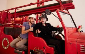 Dois homens estão sentados num camião dos bombeiros. em Fire Station Inn em Adelaide