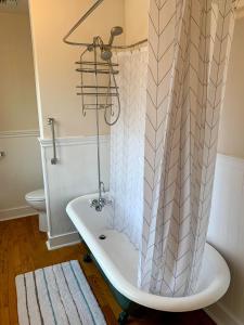 a bath tub with a shower curtain in a bathroom at Riverpath Inn in Eugene