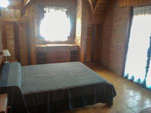 a bedroom with a bed and two windows at Cabaña Ostende in Ostende