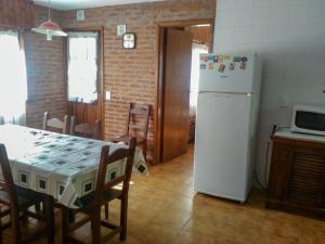 a kitchen with a table and a white refrigerator at Cabaña Ostende in Ostende +18 photos