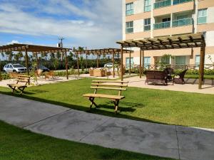 zwei Bänke in einem Park mit Pavillon in der Unterkunft Muro Alto Condomínio Clube - Apto 314 in Porto De Galinhas