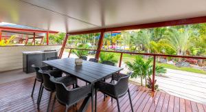 porche con mesa y sillas en la cubierta en BIG4 Adventure Whitsunday Resort, en Airlie Beach