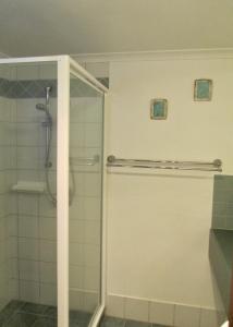 a shower with a glass door in a bathroom at Cowrie Chalet in Augusta