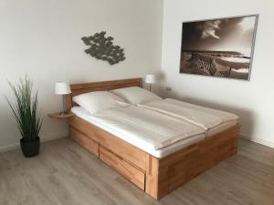 um quarto com uma cama com uma estrutura em madeira em Steiner Strandappartements Appartement 307 Süd- Landseite em Stein