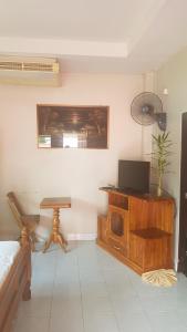 a living room with a tv on a wooden cabinet at Niracha Chaweng House in Chaweng