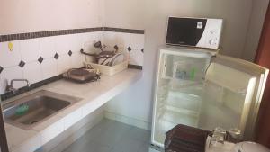 a small kitchen with a sink and a refrigerator at Niracha Chaweng House in Chaweng