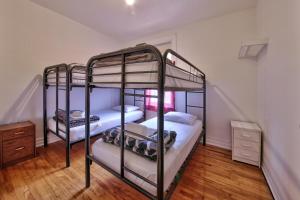 two bunk beds in a room with wood floors at Hotel Mini Inc in Montréal